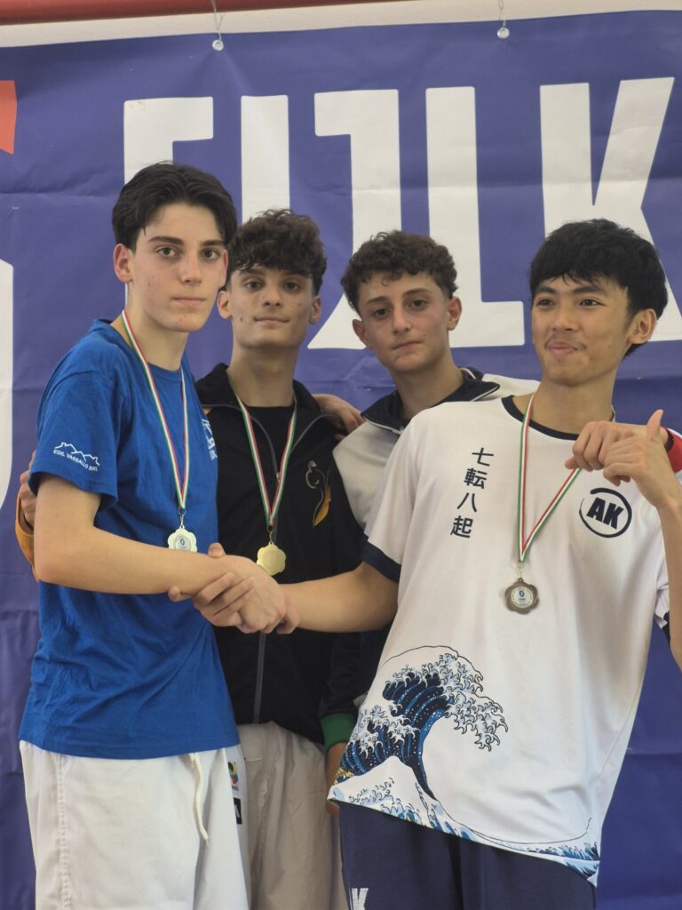 Quattro ragazzi, con le medagli al collo, sono in piedi sul podio.